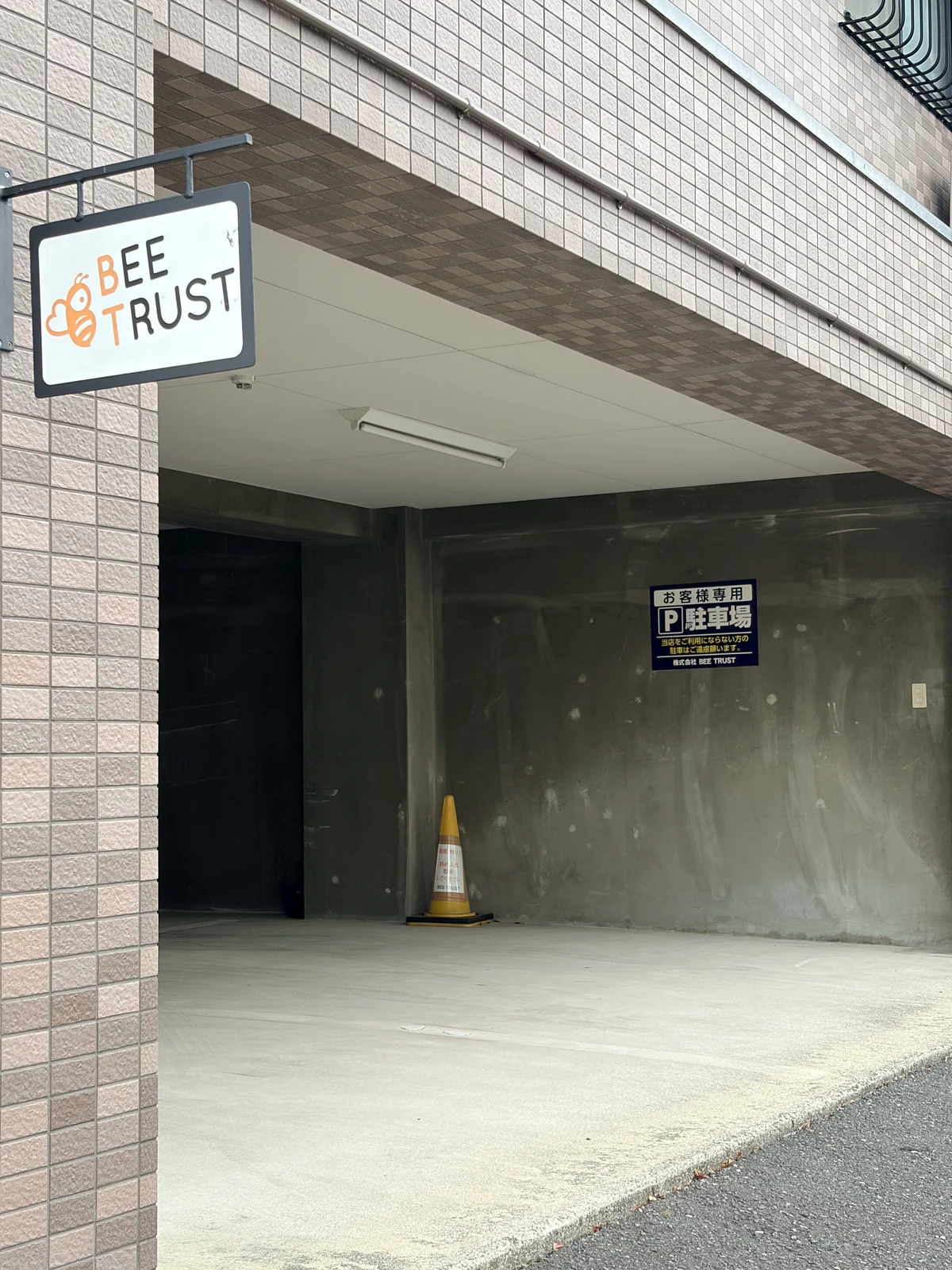 BEE TRUST専用駐車場の入口。入口に段差があるため、斜めに入庫いただくか、スタッフが別の駐車場をご案内します。